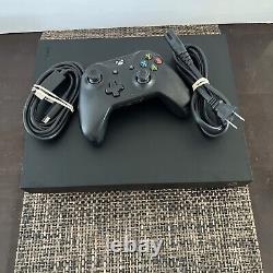Console Microsoft Xbox One X 1 To Noir en très bon état avec une manette