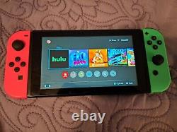 Nintendo Switch Console de jeu portable rose/vert en bon état avec carte SD de 256 Go et wifi.